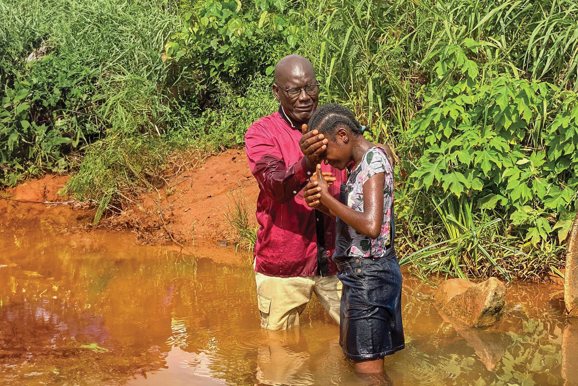 a young African girl is baptized